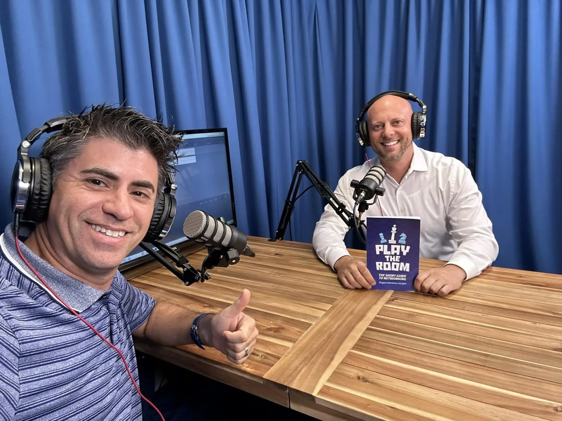 Dagan Martinez-Vargas recording a podcast interview, with a guest holding the Play the Room book